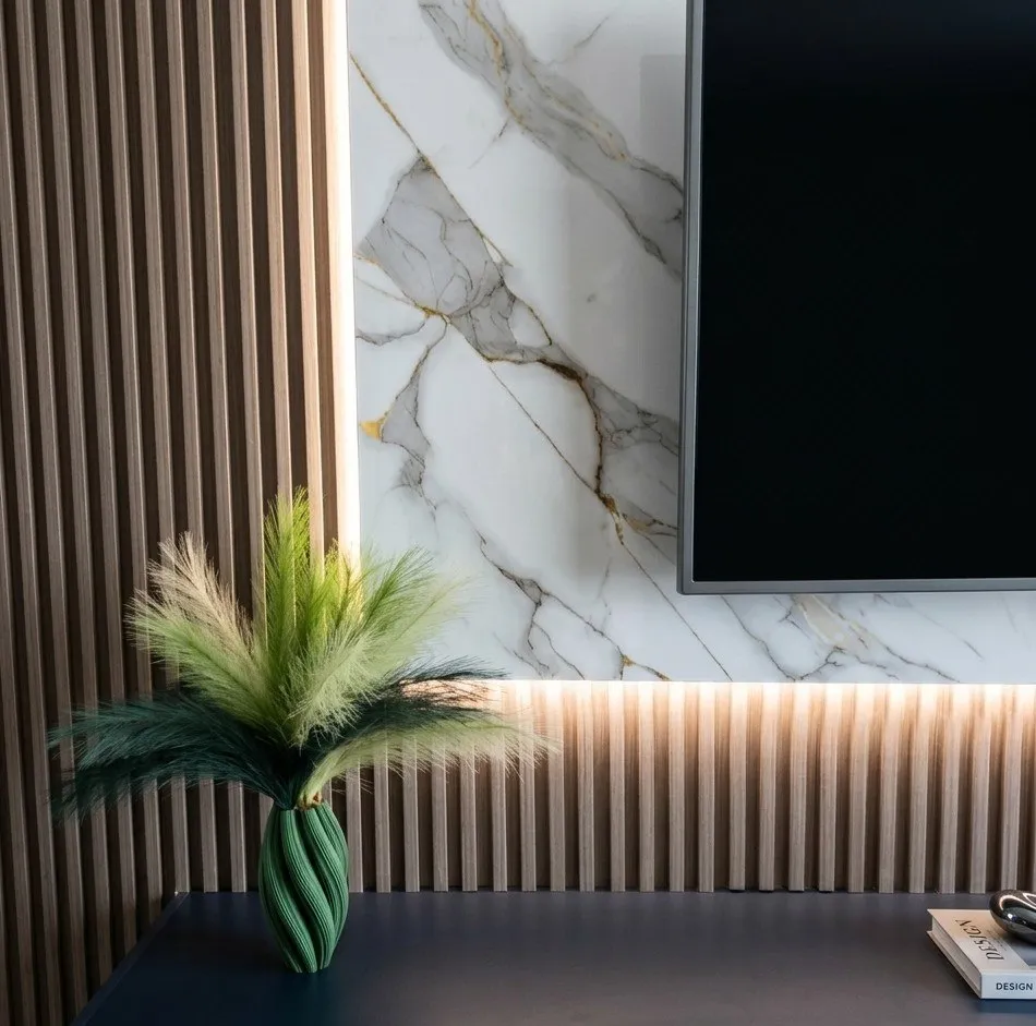 Interior con muro de mármol blanco, lambrín de madera y planta decorativa