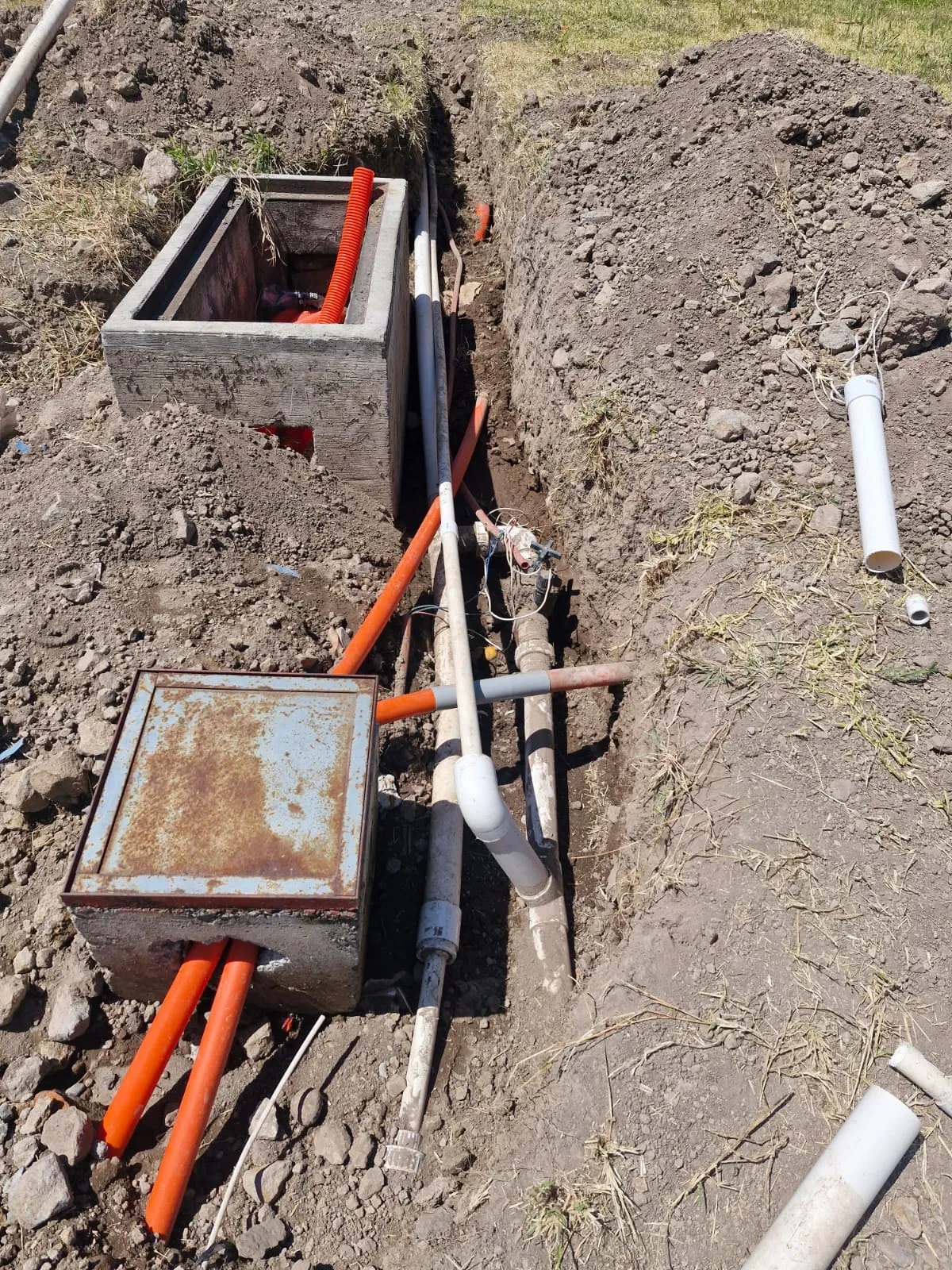 Cajas de válvulas y tubería de riego instaladas en zanja